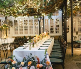 Elegant long table with white cloths, green chairs, florals, and string lights—festive New Orleans wedding inspiration.
