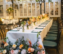 Outdoor wedding table with string lights, black chairs, and floral decor captures a festive New Orleans celebration.