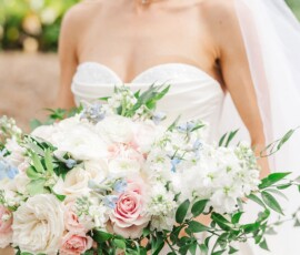 Smiling bride in strapless white dress holds pastel bouquet at her New Orleans wedding.