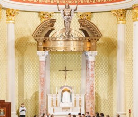 Bride and groom at the altar in an ornate church, surrounded by bridal party and guests—a beautiful Louisiana wedding scene.