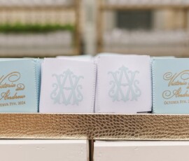 Light blue and white wedding napkins with gold and blue monograms, Victoria and Andrew, October 5th, 2024, on gold tray.