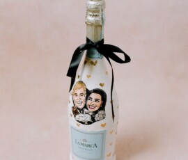 A La Marca Prosecco bottle with gold hearts, black ribbon, and a cartoon couple—ideal for New Orleans wedding keepsakes.