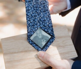 Person holding wooden box and blue floral tie with a photo inside—unique, heartfelt wedding inspiration.