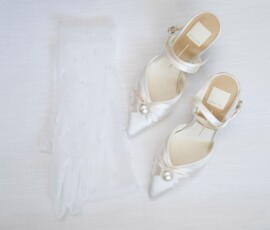 White bridal shoes with pearl accents and a beaded veil on a light background, ideal for a Louisiana wedding.