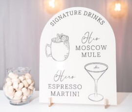 Signature Drinks sign shows His Moscow Mule and Hers Espresso Martini; a bowl of white candies sits beside the elegant display.