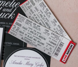 Live Nation concert tickets for Chuck and Amelie on elegant wedding invites, all set on a soft pink background.