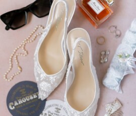 Bridal shoes, pearls, sunglasses, perfume, jewelry, and coasters styled on pink—ideal for a chic New Orleans wedding.