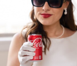 Elegant woman in white dress, pearls, gloves, and sunglasses holding Coca-Cola—timeless inspiration for New Orleans weddings.