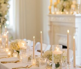 Chic table with white flowers, tall candles, and glassware in a bright room—timeless Louisiana wedding inspiration.