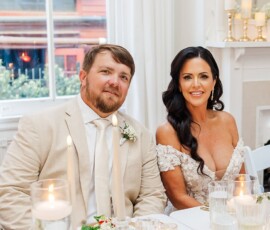 Smiling couple at a candlelit table during a Louisiana wedding celebration, perfect for wedding inspiration.