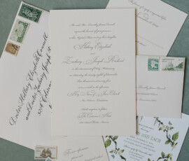 Elegant wedding invitation suite with vintage stamps, RSVP cards, and ivy accents on a blue-green surface for a New Orleans celebration.