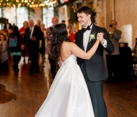 Bride and groom share a joyful first dance under string lights at a rustic, multicultural New Orleans wedding.
