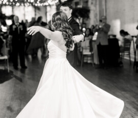 Bride and groom share a first dance under string lights at a multicultural New Orleans wedding, her white dress twirling.