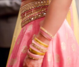 Woman in pink and gold embellished lehenga, matching bangles, and ring—stylish New Orleans wedding inspiration.