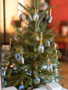 Small indoor Christmas tree with blue and gold ornaments, white gift boxes at base—ideal for cozy Louisiana wedding inspiration.