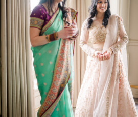 Two women in Indian attire smile indoors, preparing for a wedding at The Ritz-Carlton New Orleans.