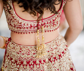 Woman in red and gold Indian wedding attire, intricate beadwork and tassels, at The Ritz-Carlton New Orleans.