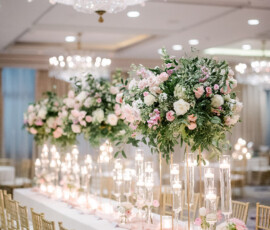 Luxurious banquet table with gold chairs, pink and white floral centerpieces, and crystal chandeliers at The Ritz-Carlton New Orleans.