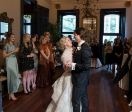 Bride and groom have their first dance at The Columns Hotel New Orleans, surrounded by smiling, photo-taking guests.