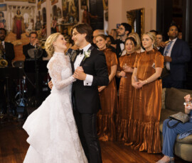 Bride and groom dance at The Columns Hotel New Orleans as guests in brown dresses watch in an elegant, art-filled room.
