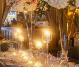 Louisiana wedding table with white linens, pink and white flowers, candles, and elegant tableware in warm light.