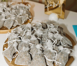 Lavender-filled mesh bags on a gold tray with a “Please take a favor” sign, perfect for Louisiana wedding inspiration.
