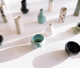 Colorful ceramic vases and bowls on a white surface, casting long sunlit shadows—ideal Louisiana wedding decor.