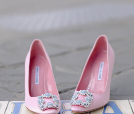 Pink high-heeled shoes with jeweled buckles sit side by side on tiled pavement, perfect for elegant wedding inspiration.