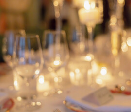 Chic dinner table with floral china, silverware, candles, and wine glasses—ideal for wedding or New Orleans celebration.