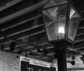 Black and white photo of a streetlamp, wooden beams, and “New Orleans The Sellars” sign—timeless Louisiana wedding inspiration.