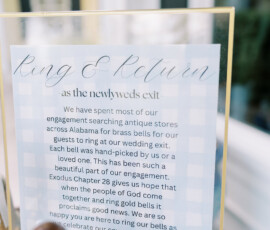A wedding sign in elegant script invites guests to ring brass bells for the couple, referencing Exodus 28 and their covenant.