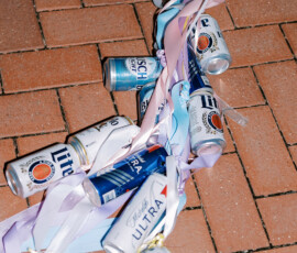 Pastel-ribbon beer cans scattered on brick pavement after a joyful New Orleans wedding, Gulf South inspiration.