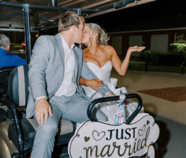 Bride and groom kiss on a golf cart with a Just Married sign at night, perfect Louisiana wedding inspiration.