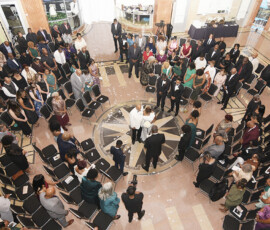 Overhead view of a New Orleans wedding, guests in a circle around the couple and officiant in a spacious hall.