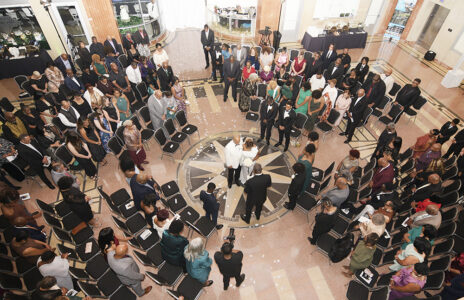 Overhead view of a New Orleans wedding, guests in a circle around the couple and officiant in a spacious hall.