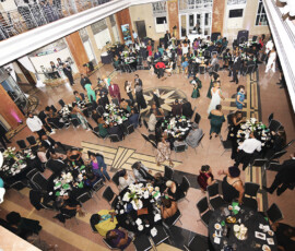 Elegant indoor banquet with round tables, guests in formal wear, high ceilings, and festive balloon décor for a New Orleans wedding.