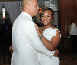 A couple in white formalwear smiles while dancing in an elegant art-deco hall, showcasing Gulf South wedding inspiration.