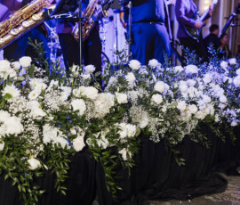 A band plays saxophones and sings on stage with white flowers, creating classic Louisiana wedding inspiration.