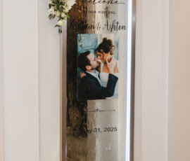 Elegant wedding welcome sign with white flowers, couple’s photo, and date on a mirrored surface—New Orleans wedding inspiration.