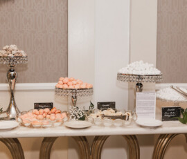 Elegant dessert table with pastel macarons, powdered treats, and candies on glass stands—ideal for Gulf South weddings.