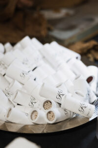 White matchstick holders with monograms and matches on a metallic tray, ideal as unique Gulf South or New Orleans wedding favors.