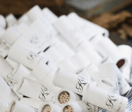 White matchstick holders with monograms and matches on a metallic tray, ideal as unique Gulf South or New Orleans wedding favors.