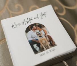Wedding napkins featuring a kissing couple and their dog, labeled “Kris, Ashton and Yeti,” dated May 31, 2025.