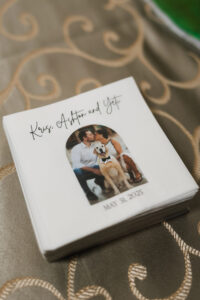 Wedding napkins featuring a kissing couple and their dog, labeled “Kris, Ashton and Yeti,” dated May 31, 2025.