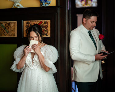 Bride and groom read letters back to back before their Gulf South wedding; bride emotional, groom calm in white suit.