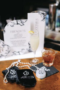 Signature cocktail display featuring a French 75 and Manhattan menu with elegant black-and-white bar signage.