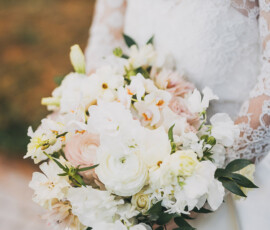 Bride in lace wedding dress holding white and pale pink flower bouquet, ready for her New Orleans wedding.
