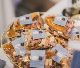 Gold bowl with bagged dog treats in blue-labeled bags, perfect for Louisiana wedding tables or pet-friendly receptions.
