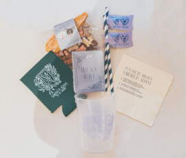 Gulf South wedding welcome kit with snacks, blue straws, green drink sleeve, purple mints, clear cup, and fun fact napkin.