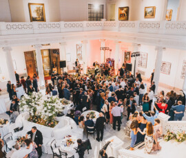Elegant New Orleans wedding with a band, formal guests, white columns, artwork, and lush flower arrangements.